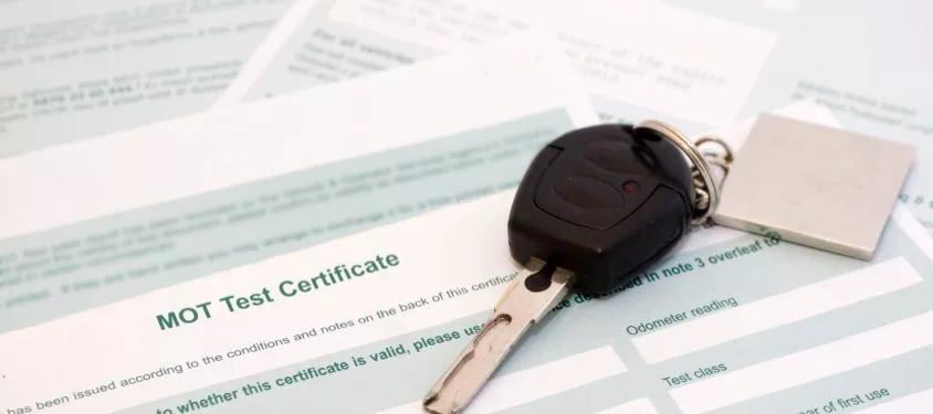 An MOT test certificate with car keys resting on it. 
