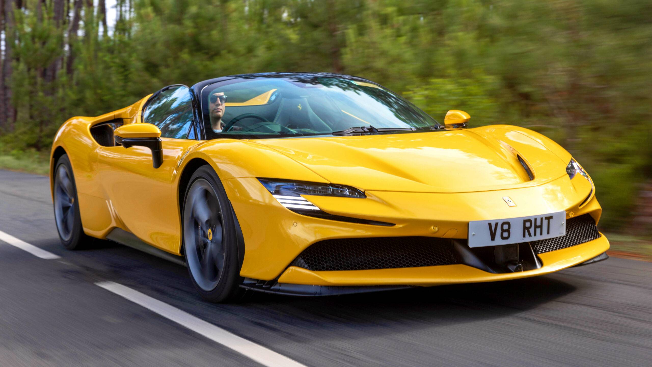 The Ferrari SF 90 Spider in yellow on a road.