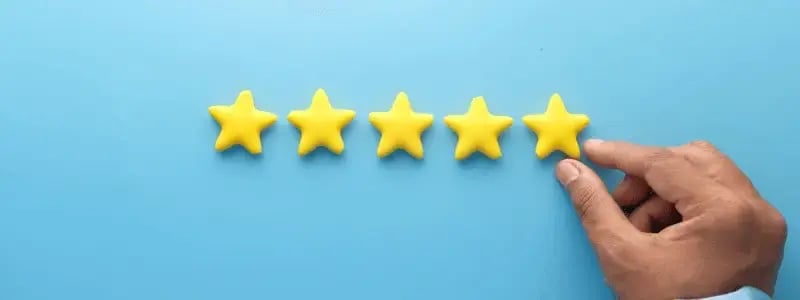 A hand placing stars together to form a line making up five stars.
