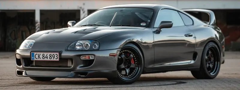 A black Cupra sports car parked in an industrial setting.
