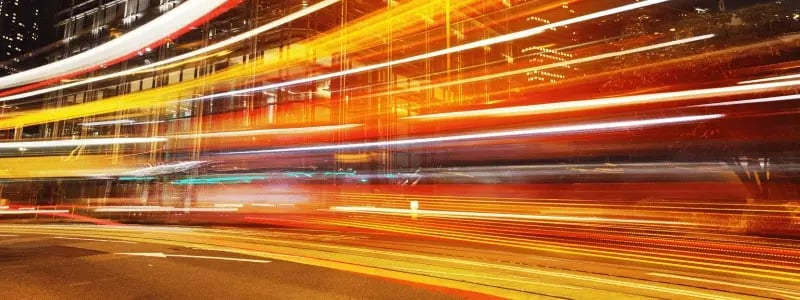 Shutter photo style with blurs flashing across a road, indicating speed.