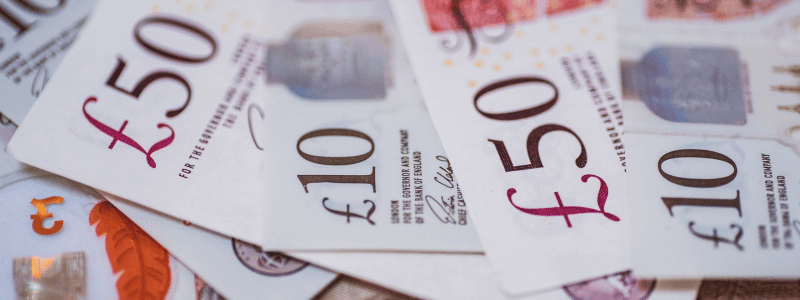 A close up of British money, with £50 and £10 notes in focus.