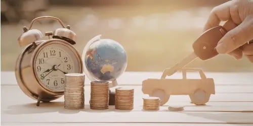 A model car with coins and a clock, representing car buying and timing.