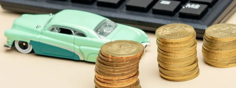 A model car in front of stacks of coins, symbolising car loan lending.