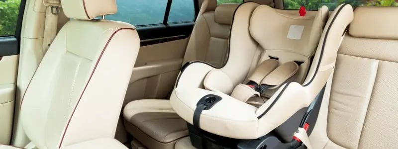 An empty car seat in a car with a cream interior.