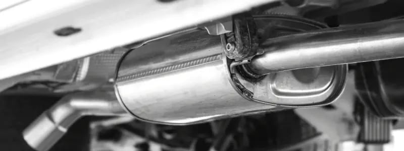 An under-view of a car, with a catalytic converter on view.