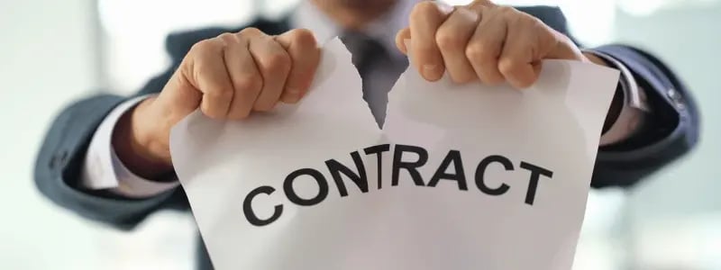 A business person ripping a sheet of paper that reads 'CONTRACT', indicating the end of a contractual agreement.