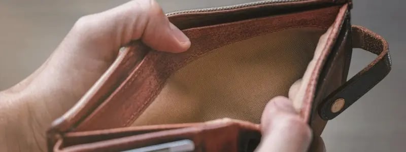 A person looking in their wallet which is empty, indicating they have money troubles.