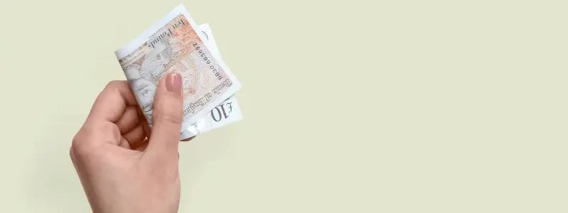 A person holding up cash.