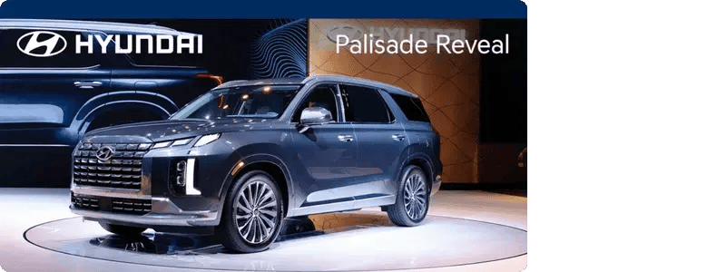 The dark blue Hyundai Palisade in a car showroom setting.