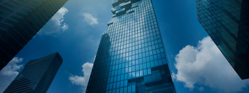 An upwards shot of buildings against a blue sky background.
