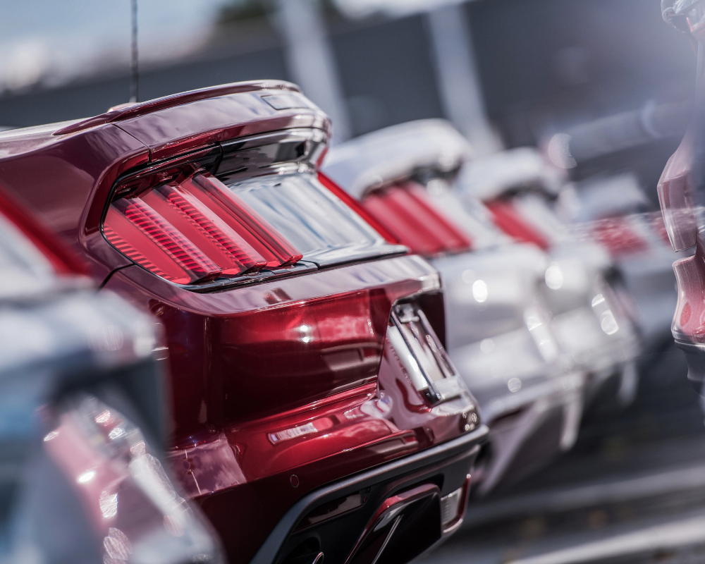 A group of cars lined up one after the other, outside.