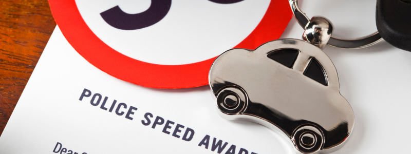 A close up of paper saying police speed awareness, with a car keyring on top.