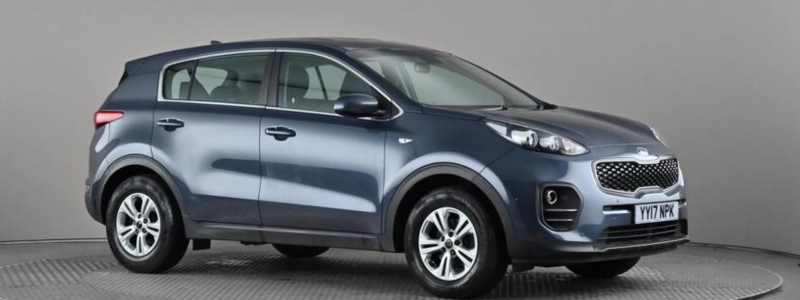 A Kia Sportage parked side-on in a car showroom setting.
