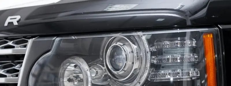 A close up of the front of a Land Rover, with the headlights visible.