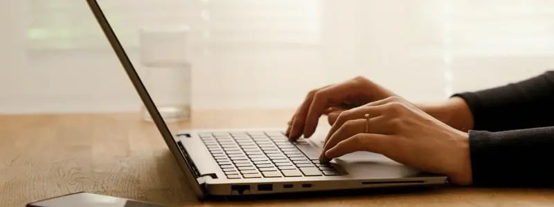 A side on view of someone using a laptop.
