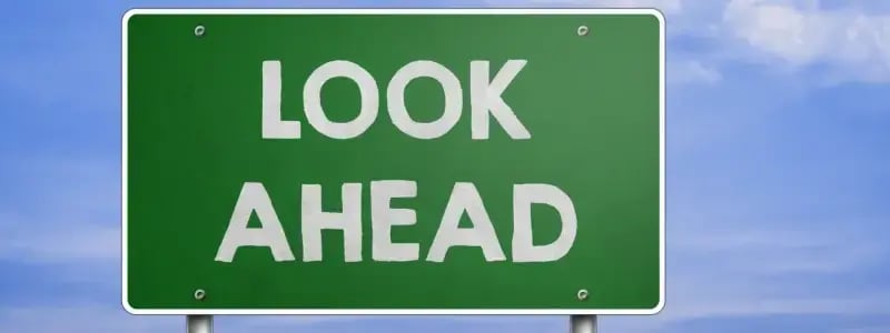 A green road sign against a blue sky background, with 'LOOK AHEAD' written on.