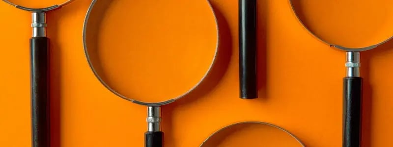Multiple magnifying glasses laid against a flat surface that's painted orange.