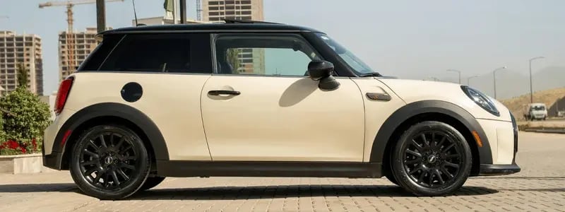 A cream Mini Hatch in a city setting.