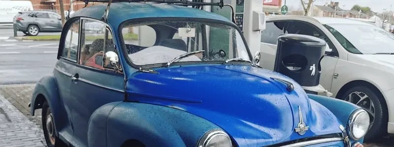 A blue Morris Miner, parked in a petrol station.