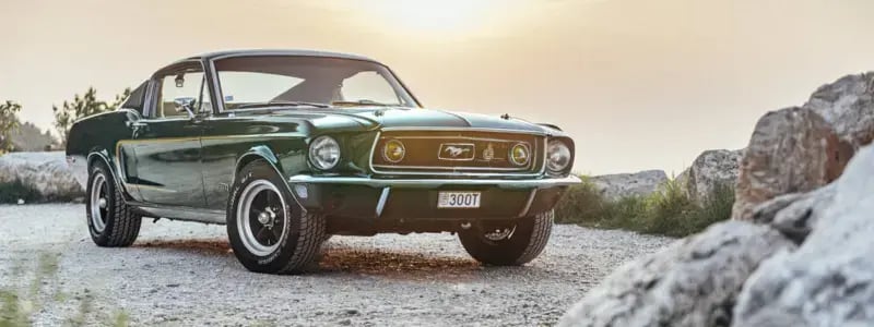 A green 1968 Ford Mustang parked in a rural setting.
