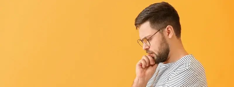 A person looking on nervously against a yellow background.