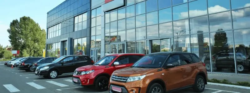 Outside a car dealership, with various different colour and types of car parked outside.
