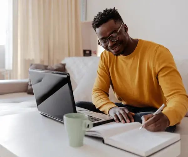 A person sat at a table working, representing self employment and study.