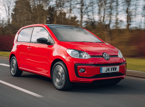 A red VW Up driving on a road.