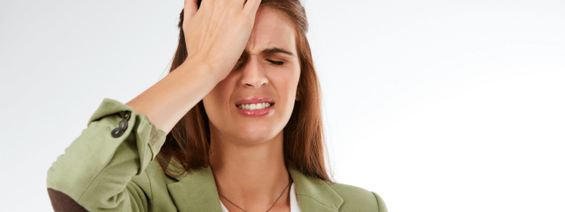A woman places the palm of their hand on their forehead, representing regret.