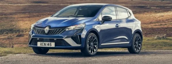 A blue Renault Clio parked in a rural location.