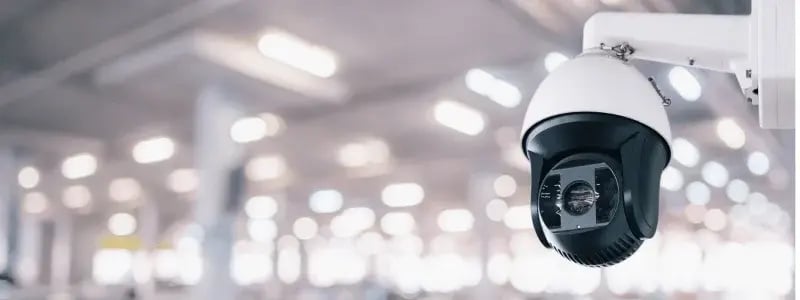A close up of a security camera in a large building.