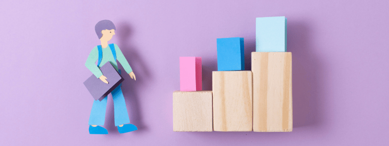 A cartoon of a worker waiting to walk up stairs with different colour blocks.