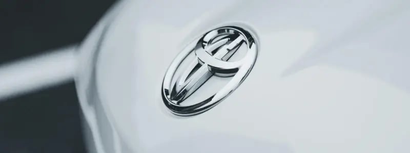 A close up of a Toyota badge on a white car.
