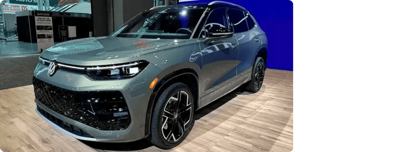 A VW Tiguan SEL R-Line Turbo in a car showroom setting.