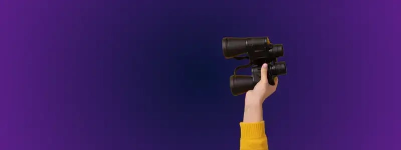 A hand holding binoculars up against a purple and blue background.