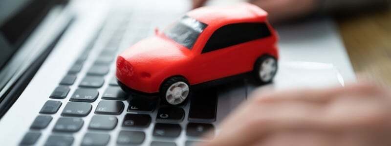 A toy car on a laptop, symbolising an online car search.