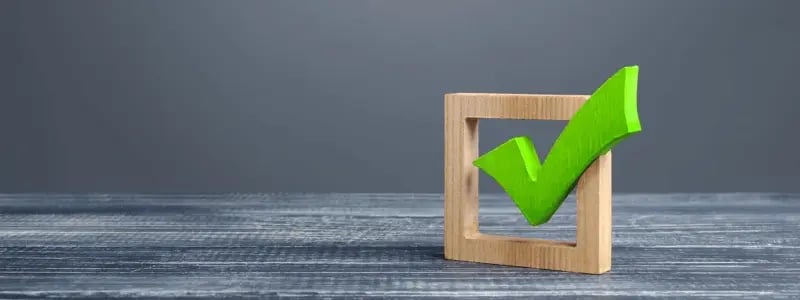 A green tick attached to a wooden box outline against a grey background.