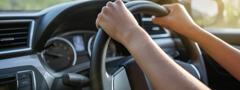 A close up of someone holding a steering wheel.