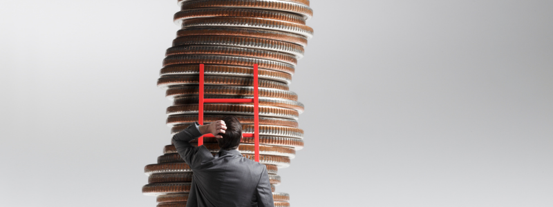 A person looking up at a stack of coins rising above them.