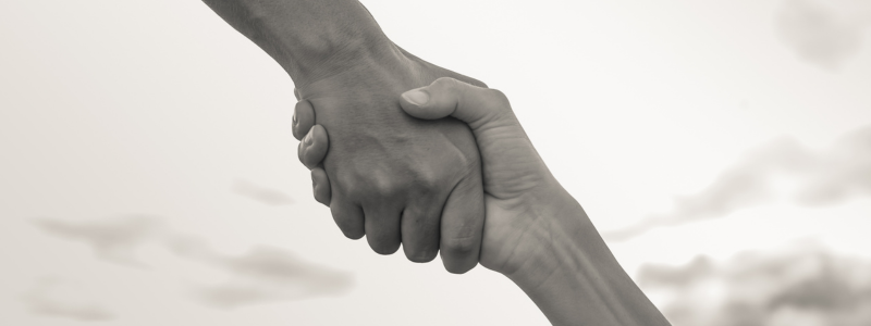 Two hands connect in a handshake.